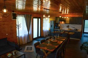 a living room with a table and a kitchen at Micesti Chalet in Miceşti