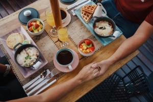 a person sitting at a table with food and drinks at Cocli Hotel Boutique Salento in Salento