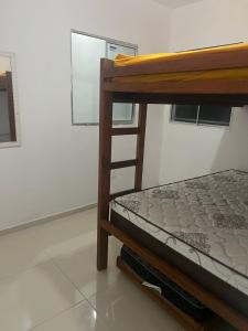 a wooden bunk bed in a room with a window at Casas de Temporada Condomínio Lene Andrade in Valença +26 photos