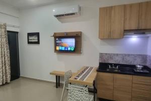 a kitchen with a sink and a tv on the wall at Mono ambiente costanera in Encarnación