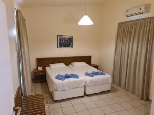 a bedroom with two beds with blue towels on them at Nissiana Hotel & Bungalows in Ayia Napa