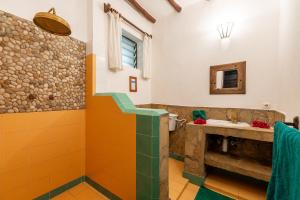un bagno con piastrelle arancioni e verdi e un lavandino di Diani Marine Divers Village a Diani Beach Altre 37 foto