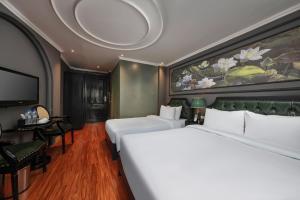 a hotel room with a large bed and a tv at Madelise Stardust Hotel & Travel in Hanoi