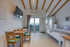 TinjanにあるLAVANDA - Relax in Greenery & Explore Istriaのベッドルーム1室、ダイニングルーム(ベッド1台、テーブル、椅子付)