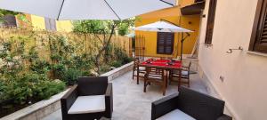 a patio with a table and chairs and an umbrella at Trastevere incantevole con patio esterno privato in Rome