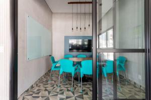 a dining room with a table and blue chairs at Hospedagem Sofisticada em Perdizes – Próxima ao Allianz Parque e Espaço Unimed in Sao Paulo
