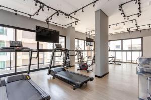 a gym with a treadmill and a flat screen tv at Hospedagem Sofisticada em Perdizes – Próxima ao Allianz Parque e Espaço Unimed in Sao Paulo