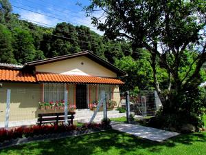 ein kleines Haus mit einer Bank im Hof in der Unterkunft Kantinho da Serra in Nova Petrópolis