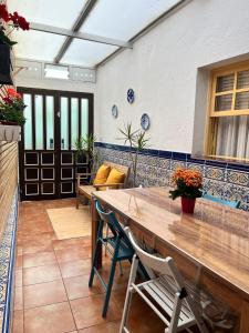 Un patio con una mesa y sillas de madera. en Casa del Molino, en Icod de los Vinos