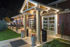 a pergola with lights on a patio at night at Hotel Sol del Añelo in Añelo +26 photos