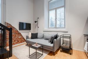 a living room with a couch and a tv at Stylish Loft next to City Center & Lake Pyhäjärvi in Tampere