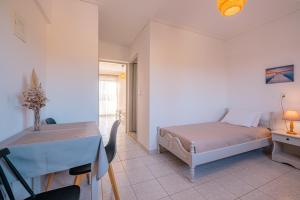 a bedroom with a bed and a table and a desk at Anthia Apartments in Marmari
