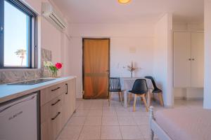 a kitchen with a sink and a table with chairs at Anthia Apartments in Marmari