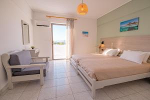 a bedroom with a bed and a chair and a window at Anthia Apartments in Marmari