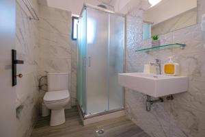 a bathroom with a toilet and a sink and a shower at Anthia Apartments in Marmari