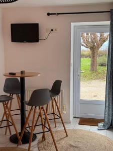 a living room with a table and chairs and a television at Au Chevaleins in Chaleins