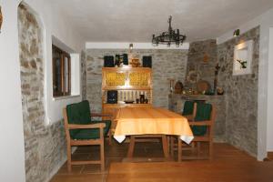 a dining room with a table and green chairs at Apartment Vínny Dom in Viničky