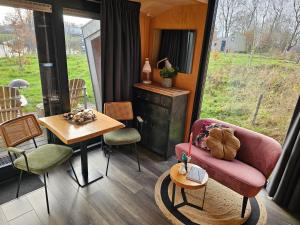a living room with a couch and a table at Tiny House De Skries in Westergeest