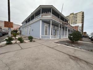 a white building with a balcony on a street at Hostal Casa Norte in Iquique