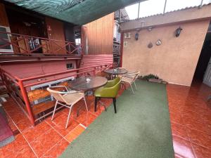 a room with two tables and chairs and a piano at Hostal Casa Norte in Iquique