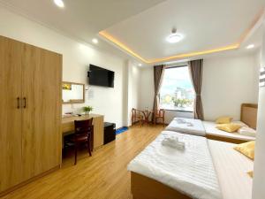 a hotel room with two beds and a desk at VICTORIA hotel in Can Tho