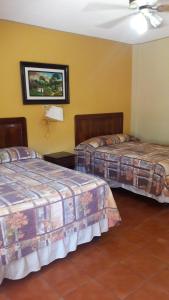 A bed or beds in a room at Hotel Brisas de Copan