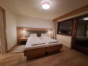 een slaapkamer met een bed en een groot raam bij Berghaus Praxmarer in Längenfeld +29 foto's