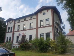 弗罗茨瓦夫PSI Koszarowa的一座白色的大建筑,旁边有一个钟