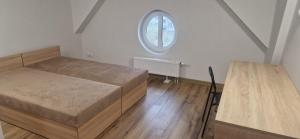 a bedroom with two beds and an oval window at PSI Koszarowa in Wrocław