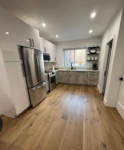 a kitchen with stainless steel appliances and wooden floors at Stunning Family Style Duplex in New York