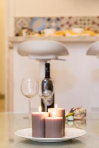 um prato com velas e uma garrafa de vinho em Dammuso Suite Noto em Noto