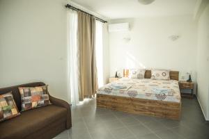 une chambre avec un lit et un canapé dans l'établissement Вила Арапя, à Tsarévo