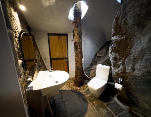 ein Steinbad mit einem Waschbecken und einem WC in der Unterkunft Forest Heaven Eco Resort in Belihuloya + 15 Fotos