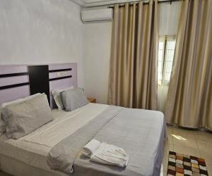 a bedroom with a bed with two towels on it at Villa Blue Serenity in Lomé