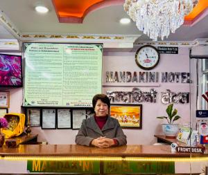 Un uomo seduto al bancone in un ristorante di Om Mandakini Hotel a Kathmandu