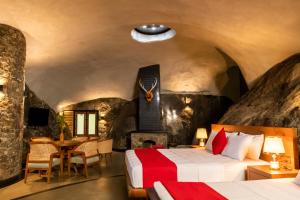 ein Hotelzimmer mit einem Bett und einem Tisch und Stühlen in der Unterkunft Forest Heaven Eco Resort in Belihuloya