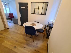 a room with a table and chairs and a mirror at La cigogne d'Alsace 2 in Sélestat