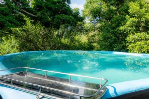 a blue pool of water on a boat at Forest Heaven Eco Resort in Belihuloya