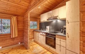 a kitchen in a log cabin with wooden walls at Cozy Home In Masserberg With Wifi in Masserberg