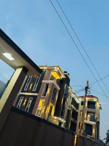 a tall building with yellow windows on a street at Haven Homes in Kampala