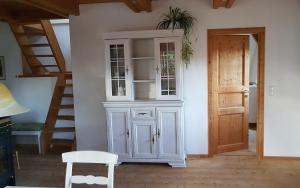 a white cabinet in a room with a staircase at Ferienwohnung 1880 in Burggen