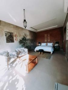 a large bedroom with a bed and a table at The balangan studio room 3mins to balangan beach in Uluwatu