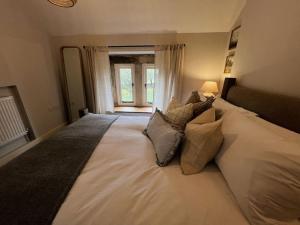 ein großes weißes Bett in einem Schlafzimmer mit Fenster in der Unterkunft Primrose cottage in Buxton