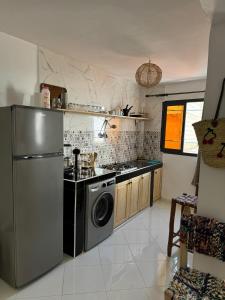 a kitchen with a stainless steel refrigerator and a dishwasher at L'étoile de taghazout in Taghazout +7 photos