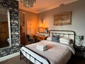 a bedroom with a bed with towels on it at Kelston Guest House in Weymouth