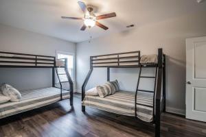 a room with three bunk beds and a ceiling fan at Island Escape Relax and Unwind in Pawleys Island in Pawleys Island