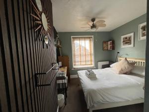 a bedroom with a bed and a clock on the wall at Kelston Guest House in Weymouth