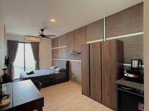ein Schlafzimmer mit Bett und Holzschränken und eine Küche in der Unterkunft Stylish Studio 2PX, Emporis Near MRT KD, Segi & Thomson Hospital in Petaling Jaya