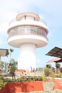 a lighthouse in front of a building at Daman View Tower Resort Pvt Ltd in Pālung