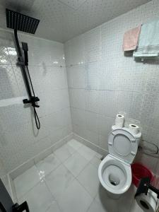 a white bathroom with a toilet and a shower at L'étoile de taghazout in Taghazout